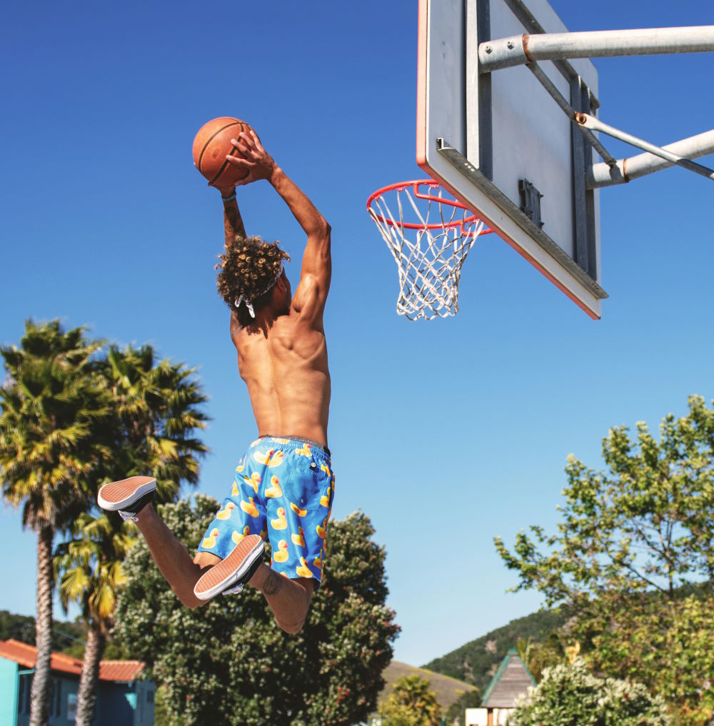 A boy trying to slam dunk a basketball on a court in PA
